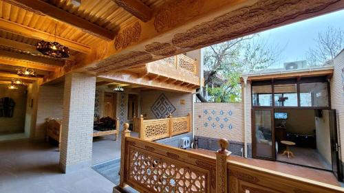 eine Veranda eines Hauses mit einem Holzgeländer in der Unterkunft Hanifa Boutique Hotel in Samarkand