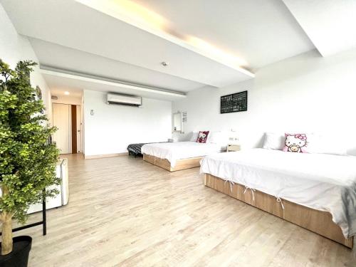 two beds in a large room with wooden floors at Nanwan 166 in Nanwan