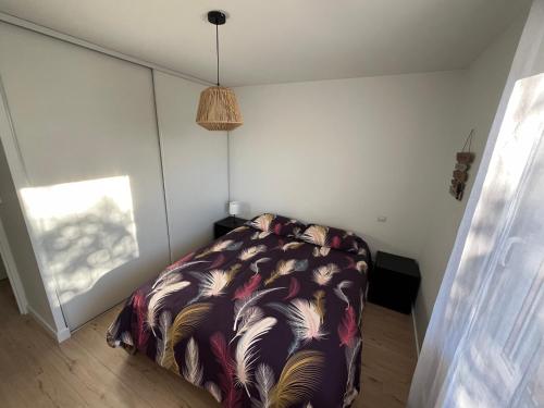 ein Schlafzimmer mit einem Bett mit einer bunten Decke in der Unterkunft Aux roches d'Or in Roques Sur Garonne
