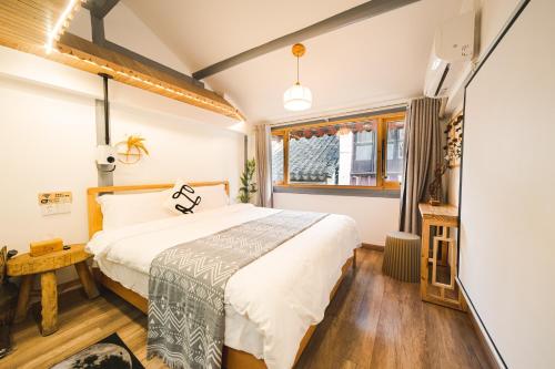 a bedroom with a large bed and a window at 2 Old Town Designer Chalet 200 year old house in Shanghai