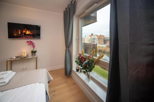 a room with a bed and a window with a view at Maya's Flats & Resorts 57 - Szafarnia in Gdańsk