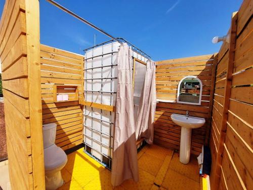 een houten badkamer met een toilet en een wastafel bij Keur Malaka in Dakar