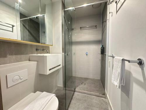 een badkamer met een douche, een toilet en een wastafel bij Avant CBD Cozy & Spacious 2BR Residences in Melbourne
