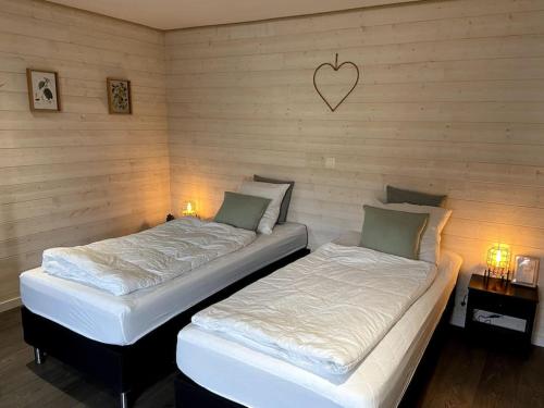 two twin beds in a room with two lamps at Ambiance boisée Moustier in Stoumont