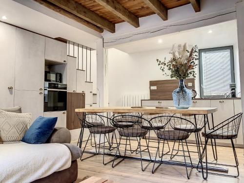 une cuisine avec une table et des chaises dans une pièce dans l'établissement La petite Luchonnaise-Maison hypercentre au calme, à Luchon