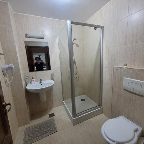 a bathroom with a shower and a toilet and a sink at La Rocca in Fundata