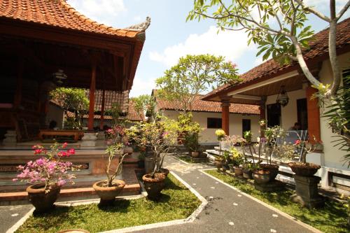 um pátio de uma casa com vasos de plantas em KT. Kuaya Home Stay em Ubud