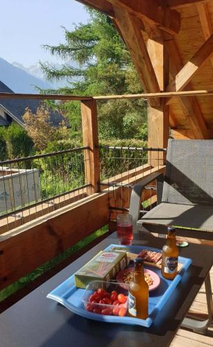een dienblad met eten op een tafel op een balkon bij WhispeRive Lodge - le vert aux bords de rive in Le Bourg-dʼOisans