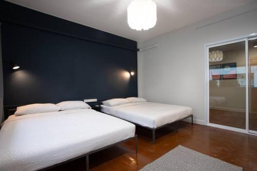 A3 Large Room, Full Facilities في بانكوك: سريرين في غرفة ذات جدار أسود