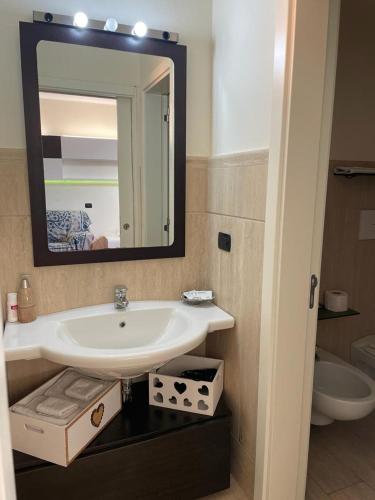 a bathroom with a sink and a mirror at Tyche Suite Luxury in Lecce