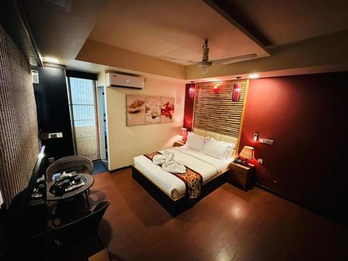 - une chambre avec un lit et un mur rouge dans l'établissement ila grand, à Hulhumalé