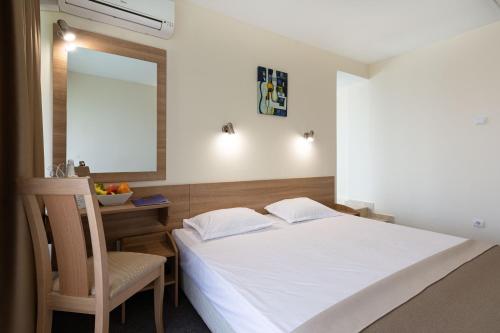 a bedroom with a bed and a chair and a mirror at BSA Gradina Hotel & Aquapark - All Inclusive in Golden Sands