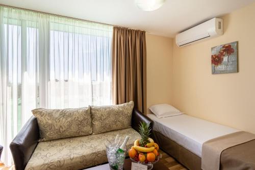 a living room with a couch and a window at BSA Gradina Hotel & Aquapark - All Inclusive in Golden Sands