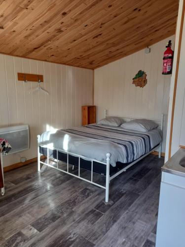 Ce lit se trouve dans un dortoir doté d'un plafond en bois. dans l'établissement L'escale en Dordogne, à Saint-Antoine-de-Breuilh