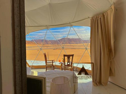 Angelina Luxury Camp في العقبة: غرفه بها كرسيين واطلاله على الصحراء