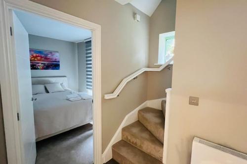 Una escalera que conduce a un dormitorio con cama en A house designed for you…, en Edmonton