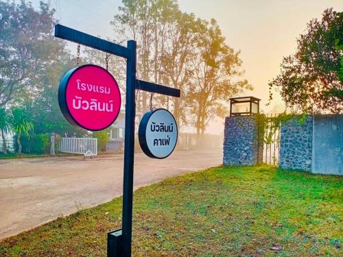 two signs on a pole in the grass at Bualinn Resort in Nong Khai