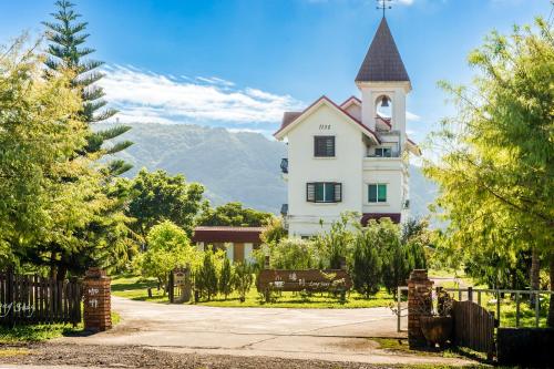 YuemeiにあるWilderness1138 Hualien B&Bの塔と柵のある白い家