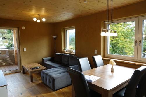 a living room with a table and a couch at Ferienwohnungen Probst in Ofterschwang