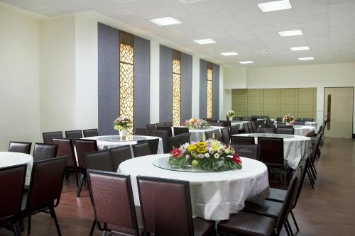 a room with tables and chairs with flowers on them at Ocean Hayline Hotel in Jian