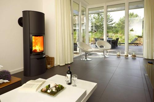 sala de estar con chimenea y mesa en Lotsenstieg 05, en Ostseebad Karlshagen