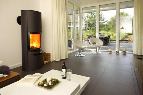 a living room with a fireplace and a table at Lotsenstieg 05 in Ostseebad Karlshagen