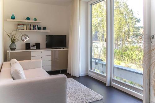 a living room with a couch and a tv and a window at Lotsenstieg 05 in Ostseebad Karlshagen