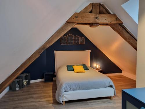 a bedroom with a bed in a attic at Le clos Champlieu in Orrouy