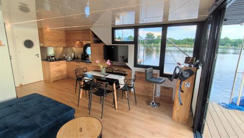 a living room and kitchen of a boat with a table and chairs at Houseboat Water King apartament pływający dom na wodzie, 7 os in Wrocław