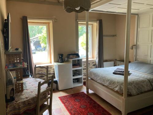 - une chambre avec un lit à baldaquin et une fenêtre dans l'établissement Le moulin du pont, chambre double indépendante., à Mordelles