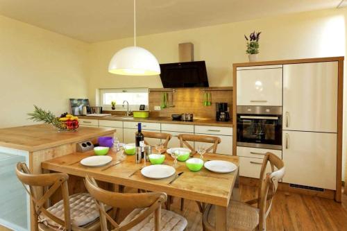 een keuken met een houten tafel met stoelen en een eetkamer bij Lotsenstieg 2 Kajuete 07 in Ostseebad Karlshagen