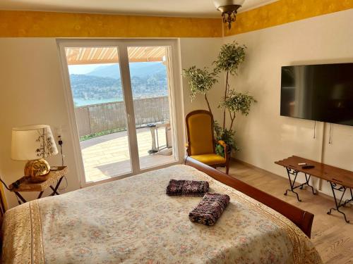 a bedroom with a large bed and a large window at Sonniges Paradies in Lugano