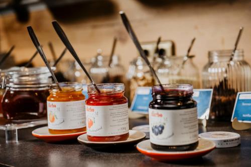 three jars of honey on plates on a counter at Hotel Landskron in Bruck an der Mur
