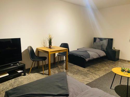 ein Wohnzimmer mit einem Bett, einem Tisch und Stühlen in der Unterkunft Schönes Wohnen in Groß-Buchholz - Zentral+Modern in Hannover