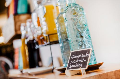 a small sign sitting on a table next to glass bottles at Hotel Landskron in Bruck an der Mur