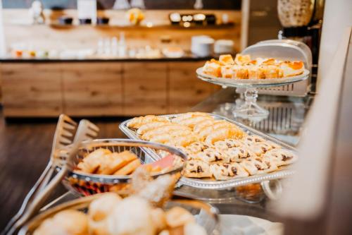 a buffet with several trays of food on a table at Hotel Landskron in Bruck an der Mur