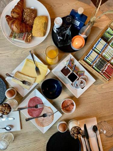 a wooden table with plates of food on it at Het Heerenlogement Beusichem in Beusichem