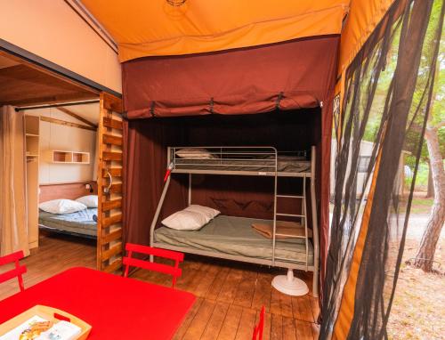 a bedroom with two bunk beds in a tent at Onlycamp Tours Val de Loire in Saint-Avertin