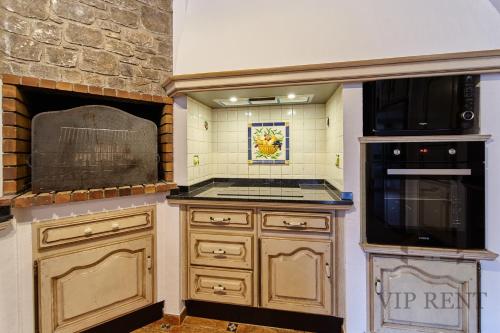 a kitchen with a stove and a microwave at Can Noguer Chalet de Lujo en Escaldes ,vistas panorámicas, jacuzzi in Escaldes-Engordany