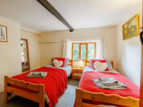 a bedroom with two beds and a window at 4 Bed in Dartmoor National Park 49535 in Sampford Courtenay