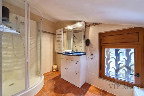 a bathroom with a glass shower and a window at Chalet Can Noguer 14 Pax in Escaldes-Engordany
