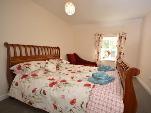 um quarto com uma cama com colcha floral e uma janela em 3 bed in Martock 51722 em Martock