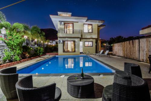 a villa with a swimming pool at night at Villan Villa Luxurious Mountain View Biggest Pool in Lonavala