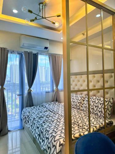 a bedroom with a bed and a large window at Deluxe Suites Razelles 2 at Shore 2 Residences Tower 1 in Manila