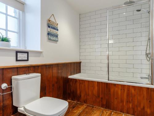 a bathroom with a toilet and a bath tub at 3 Bed in Braunton 53109 in Braunton