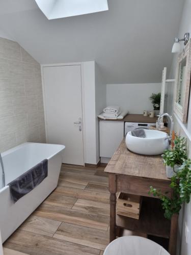 a white bathroom with a tub and a sink at Le clos Champlieu in Orrouy