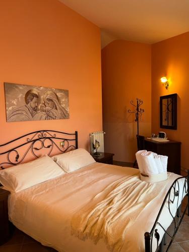 a bedroom with a large bed with orange walls at B&B Il Girasole in Castel di Sangro