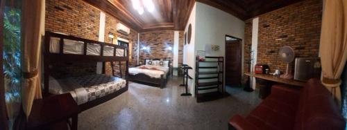 a bedroom with bunk beds in a brick wall at Hotel Khaosok and Spa in Khao Sok