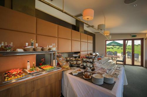 un buffet avec des plats exposés dans un restaurant dans l'établissement Grund Resort Golf and Ski, à Mladé Buky