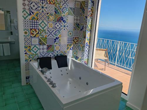 a bath tub in a bathroom next to a balcony at Grand Hotel Excelsior in Amalfi